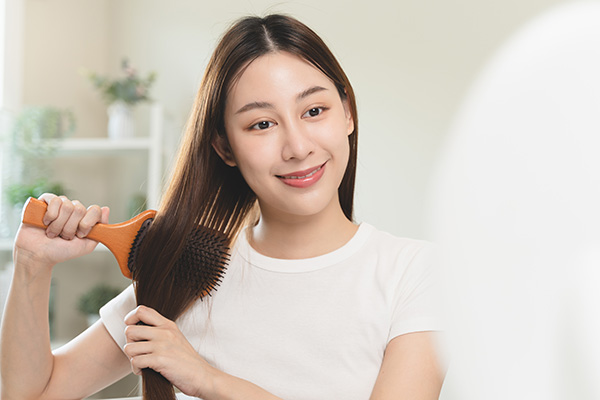Woman brushing Smooth Healthy Hair after Hair Mask